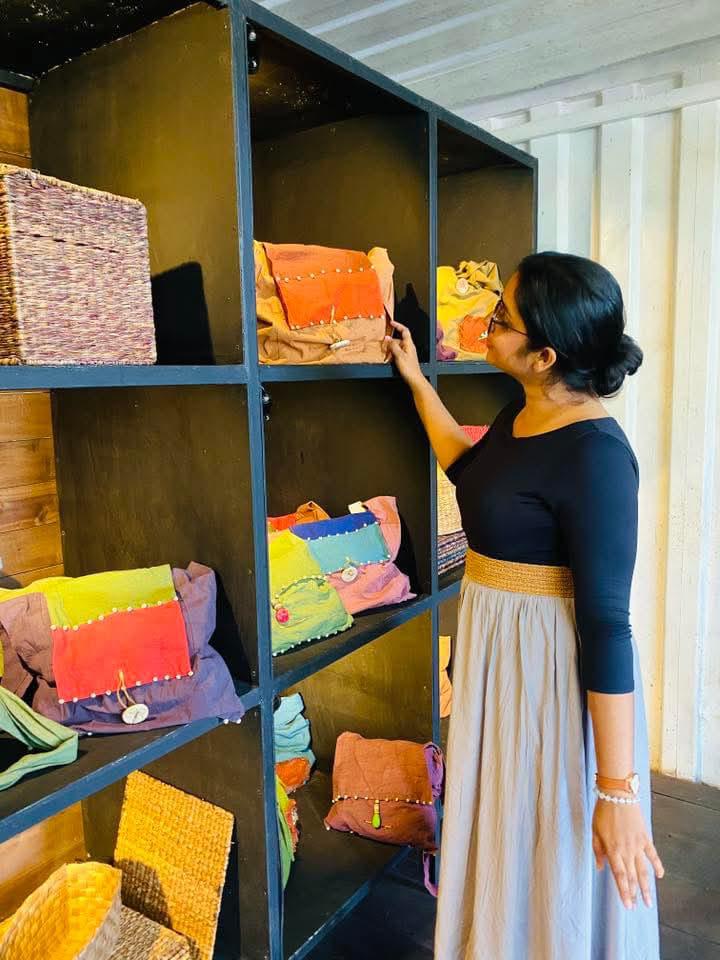 A visitor browsing handwoven bags and pouches on display at Hambu Café's gallery shop